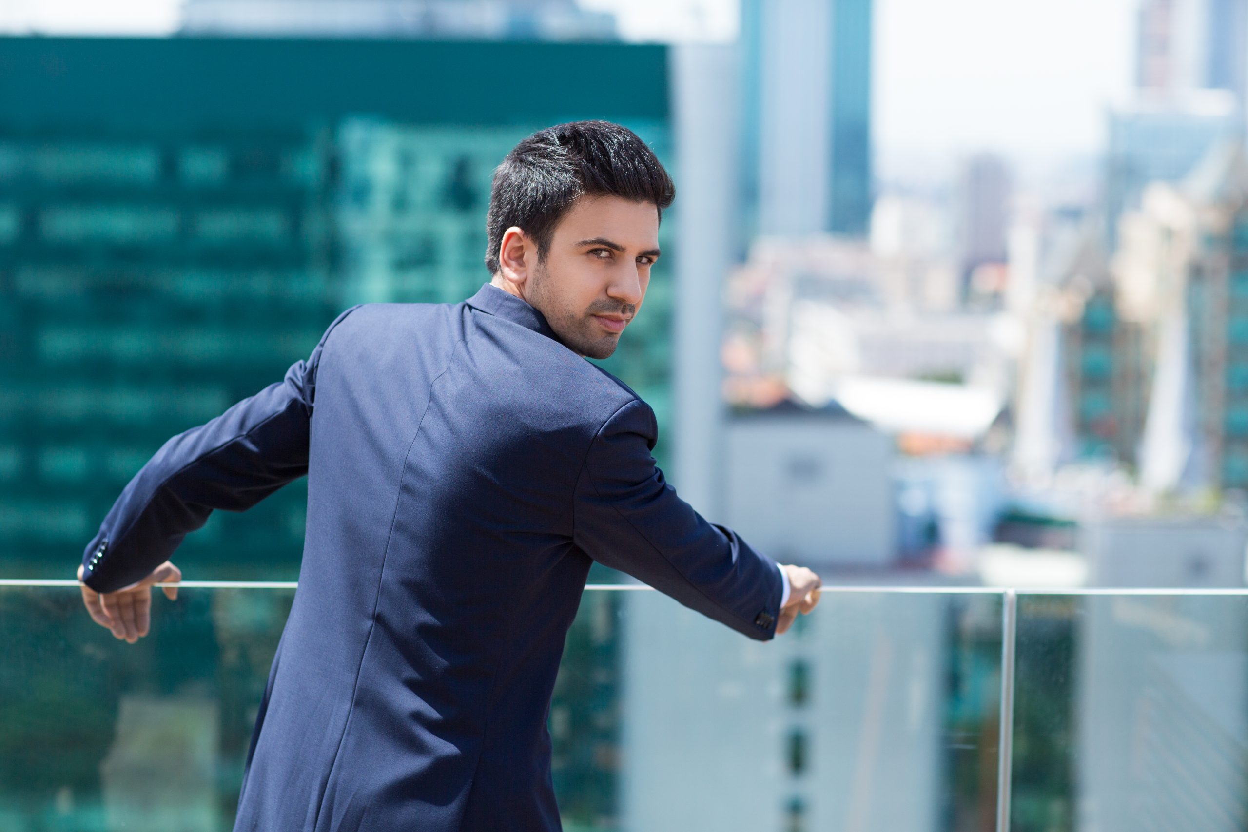 young man in black suit looking at the back